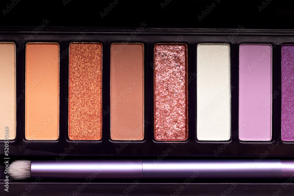 Fototapeta premium Colorful eye shadow palette background. Color eyeshadow palette with brush for day and evening eye makeup with matte and shimmer shadows