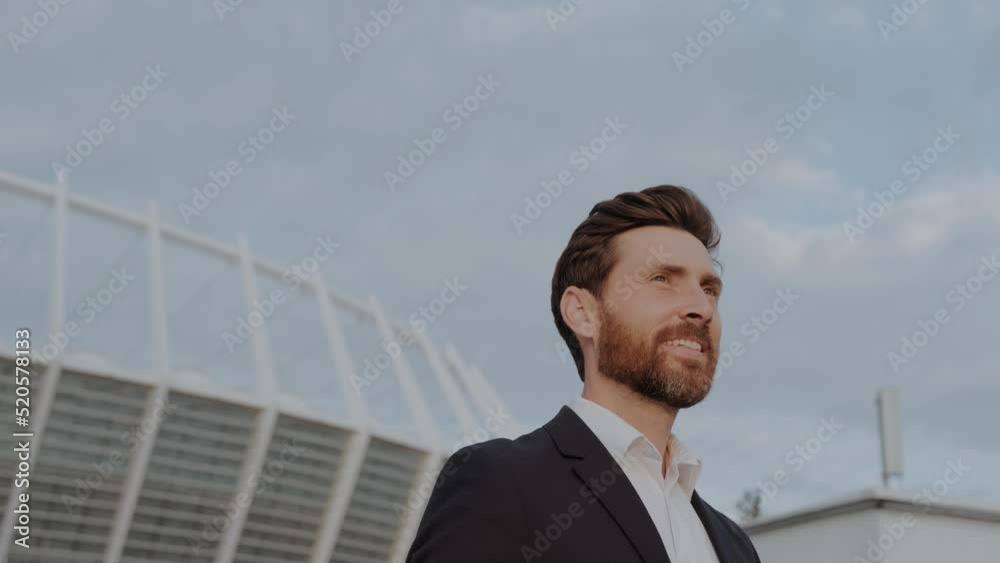 Portrait of a businessman looking at the future proud of his success and smiling. On skyscrapers background with glazed windows. Concept of: business, economy, finance, dreams, future. Portrait of a businessman looking at the future proud of his success and smiling. On skyscrapers background with glazed windows. Concept of: business, economy, finance, dreams, future.