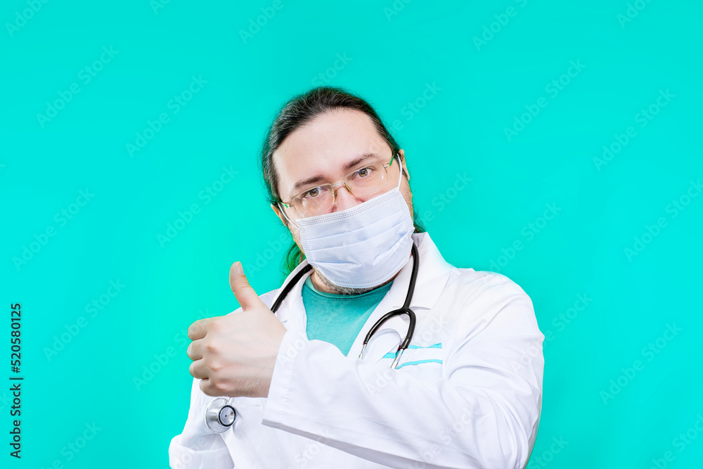 Doctor in a white coat and mask shows thumbs up. The doctor shows a gesture of approval. Doctor in a white coat and mask shows thumbs up. The doctor shows a gesture of approval.