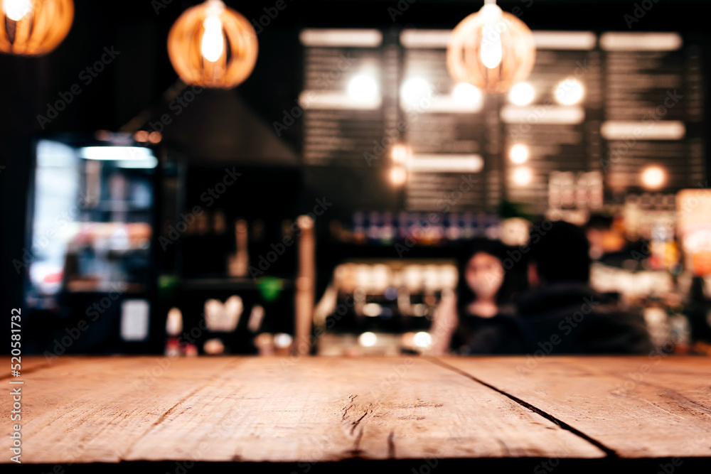 Empty blank wooden old deck table in front of abstract blurred festive background in bar, cafe, pub or restaurant with light spots and bokeh for product montage display of product. Copy space area