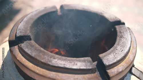 tandoor. Burning wood inside tandoor. Preheat the tandoor before preparing the kebab. cooking meat in the tandoor. photo