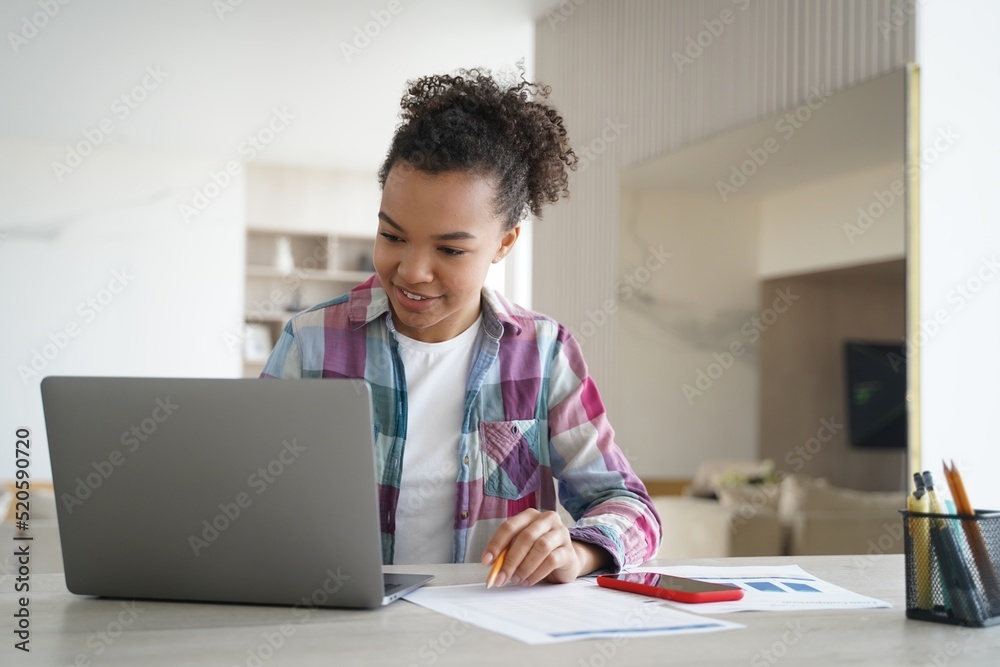 Fototapeta premium Distance learning online on quarantine. Happy afro girl is studying remote in zoom.