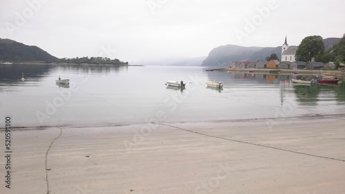 Scenic view at Seljesanden Beach in Selje, Western Norway. Boats sailing near the shore.. photo