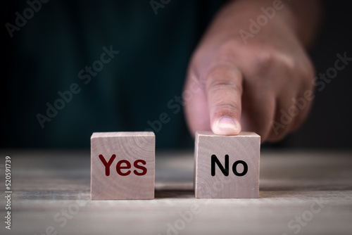 block wood cubes, Hand point finger a choice yes or no for Business concept