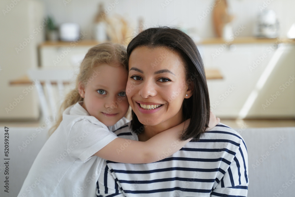 Portrait of mom and cute little girl. Blonde kid hugs mom. Handsome woman and girl together at home. Portrait of mom and cute little girl. Blonde kid hugs mom. Handsome woman and girl together at home.