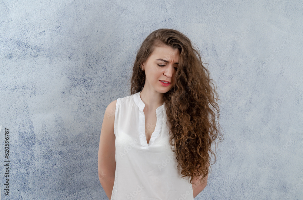 Sad young woman girl in white blouse with long curly dark hair. Sad, going to cry. Sad young woman girl in white blouse with long curly dark hair. Sad, going to cry.