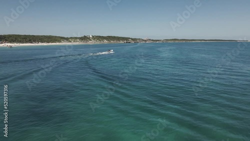 Drone shot of a boat speeding through the ocean on a sunny summer day photo