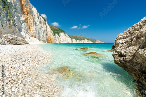 Waves of the turquoise clear sea washing the white stones of Fteri Beach, Kefalonia, Ionian Islands, Greek Islands, Greece photo