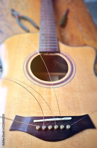 acoustic guitar strings Tool background, pliers, screwdriver. Close-up view of guitar string pins.bridge saddle.bridge