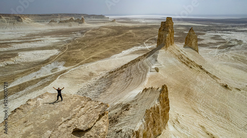 Aerial of a man standing on a cliff, Bozzhira Canyon, Ustyurt plateau, Mangystau, Kazakhstan