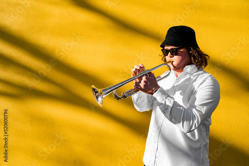 Canvas Print Young caucasian long-haired man in white shirt, hat and sunglasses playing funky