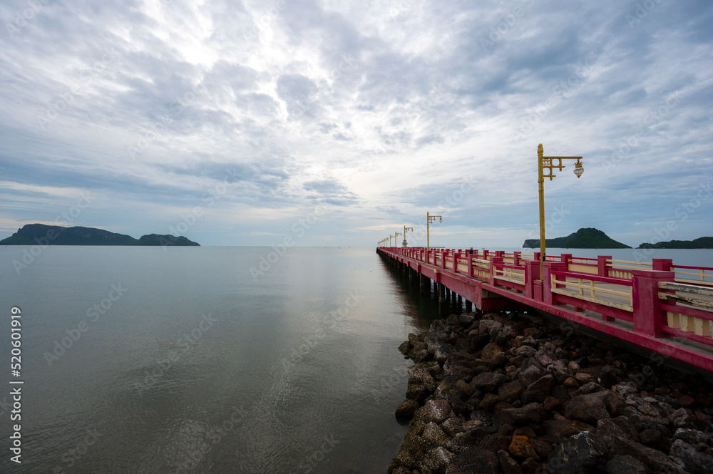 Beautiful landscape Long red pier or a bridge named Saranwithi bridge to the sea with cloud at Ao Prachuap bay Prachuap khiri khan province, Thailand. (Public domain).