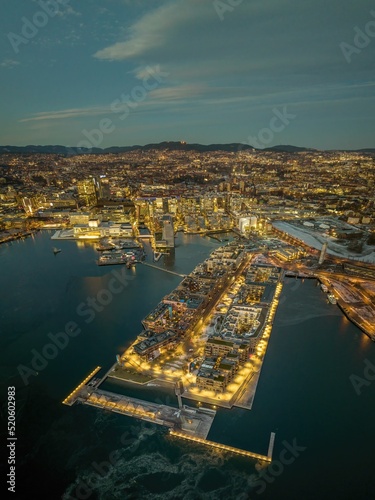Aerial shot of Oslo at sunset, with lots of buildings and lights, surrounded by sea, Norway