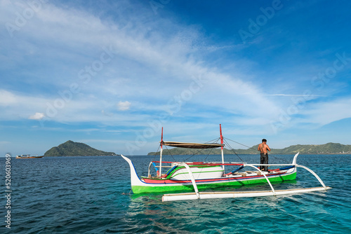 Outrigger canoe off Bahuis Island and the southern tip of Siau, Siau Island, Sangihe Archipelago, North Sulawesi, Indonesia photo
