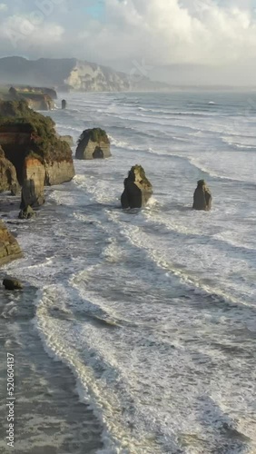 Beautiful view of ocean waves splashing on the cliffs in New Zealand
