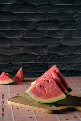 fresh watermelon slices, watermelon slices on a dark background, cold watermelon quenches thirst well in the heat, space for text 