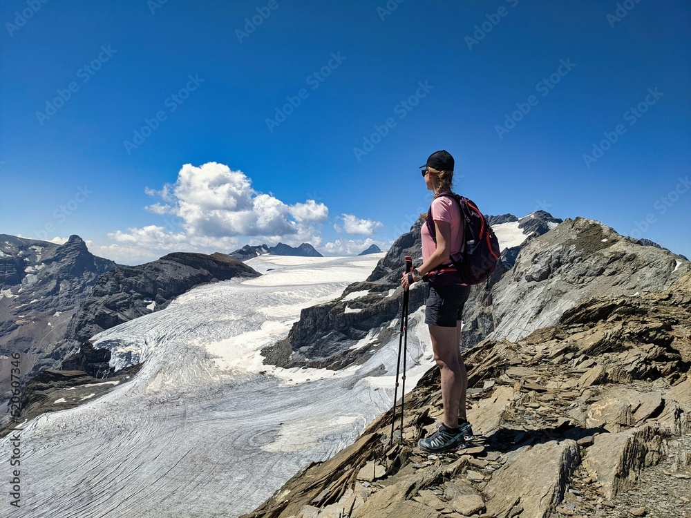 female mountaineer enjoys the view of the glaciers in the mountains in glarus. Gemsfairenstock. moment to enjoy. 