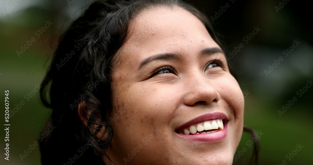 Latina girl looking at sky smiling. Hispanic young woman close-up face with HOPE and FAITH