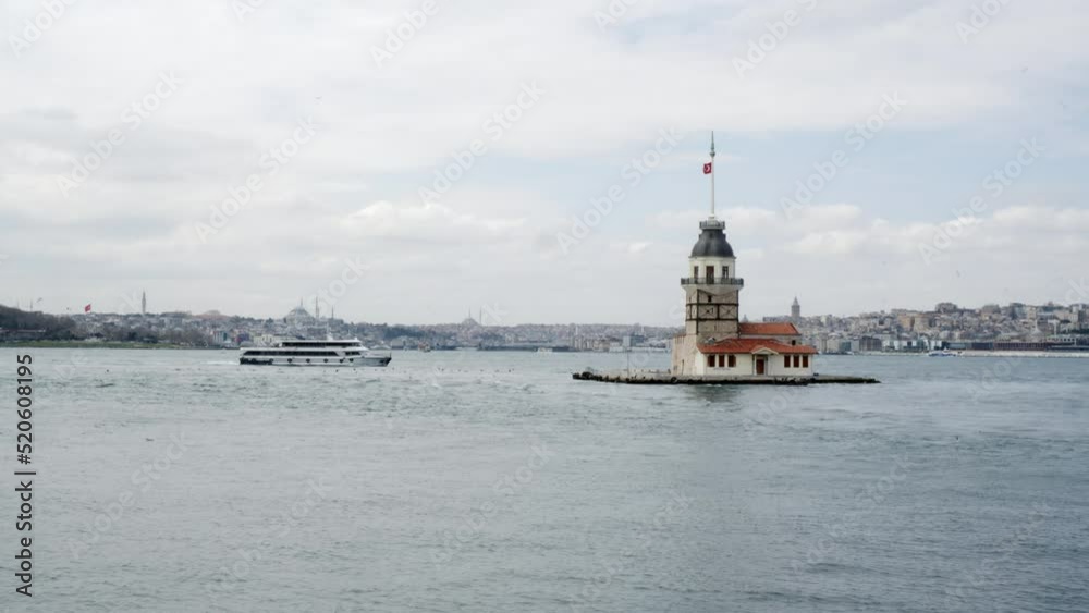 Beautiful view of ship moving by Maiden's Tower. Famous tourist attraction amidst coastal region against sky. Popular destination in Istanbul, Turkey. Beautiful view of ship moving by Maiden's Tower. Famous tourist attraction amidst coastal region against sky. Popular destination in Istanbul, Turkey.