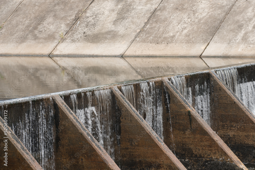 Fototapeta premium The water flow pass the weir from upper level to lower level.Water flow very fast in rainy season.Selective focus.