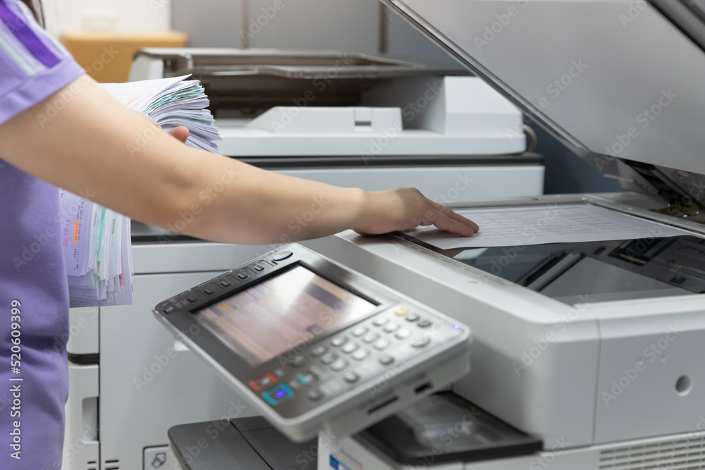 Woman standing and pressing button button on panel of printer, printer scanner laser office copy machine supplies in the office Woman standing and pressing button button on panel of printer, printer scanner laser office copy machine supplies in the office