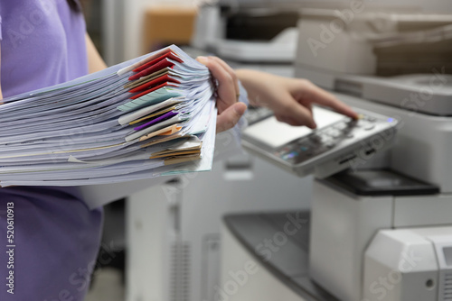 Woman standing and pressing button button on panel of printer, printer scanner laser office copy machine supplies in the office