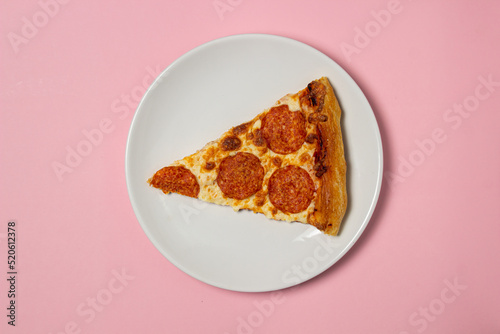 Pizza slices on a plate on a pink background. Pizza with sausage. Fast food