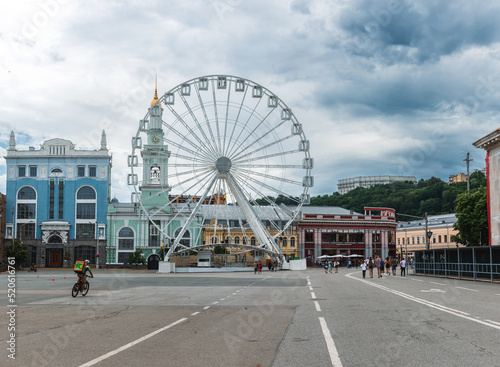 Podil, Kyiv, Ukraine - street shot of people on the main square of the Podil neighborhood with ferris wheel and traditional architecture photo