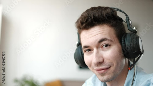 Close Up Portrait of a Joyful Technical Customer Support Specialist Talking on a Headset while Working on a Computer in a Call Center Control Room.