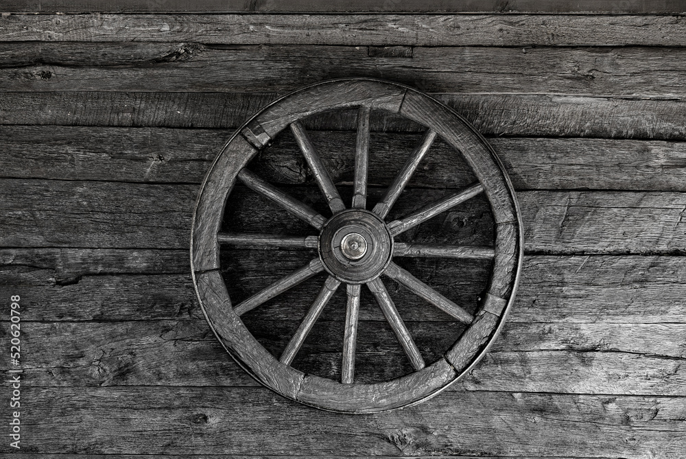 Old wooden wheel on a wooden wall. Old wooden wheel on a wooden wall.