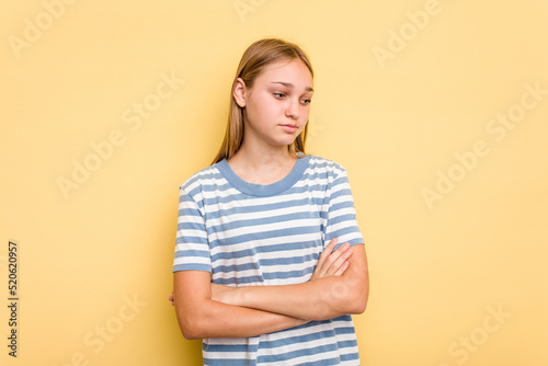 Young caucasian girl isolated on yellow background tired of a repetitive task.