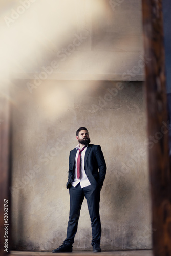 A young man with a beard in a suit in the mirror