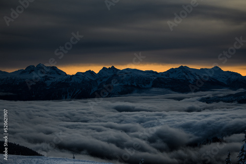 Mt Begbie and surrounding mountains under fiery sky and inversion photo