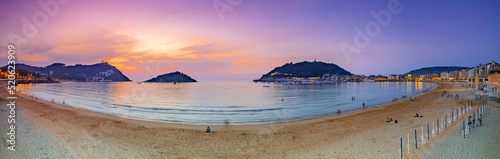 Fotografie, Obraz Nice beach with the old town of San Sebastian, Spain at gorgeous sunset