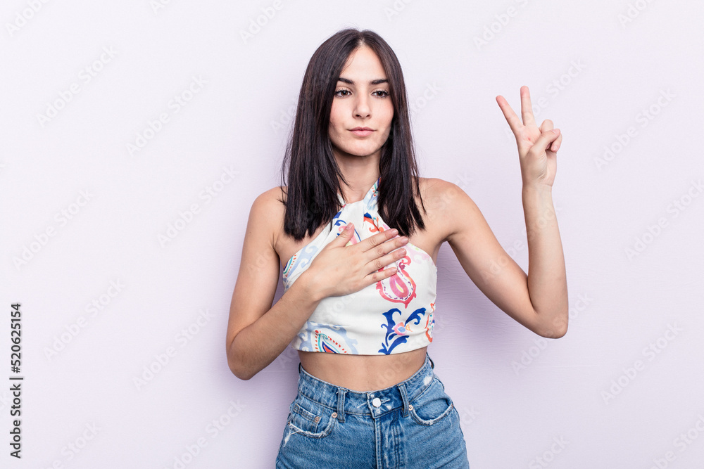 Young caucasian woman isolated on pink background taking an oath, putting hand on chest. Young caucasian woman isolated on pink background taking an oath, putting hand on chest.