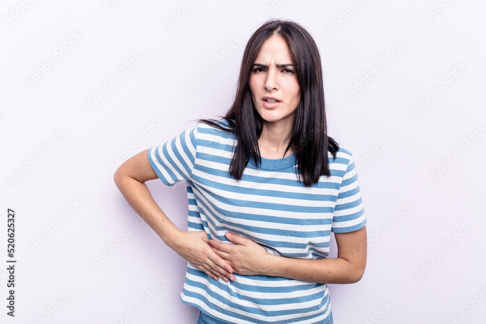 Young caucasian woman isolated on pink background having a liver pain, stomach ache. Young caucasian woman isolated on pink background having a liver pain, stomach ache.