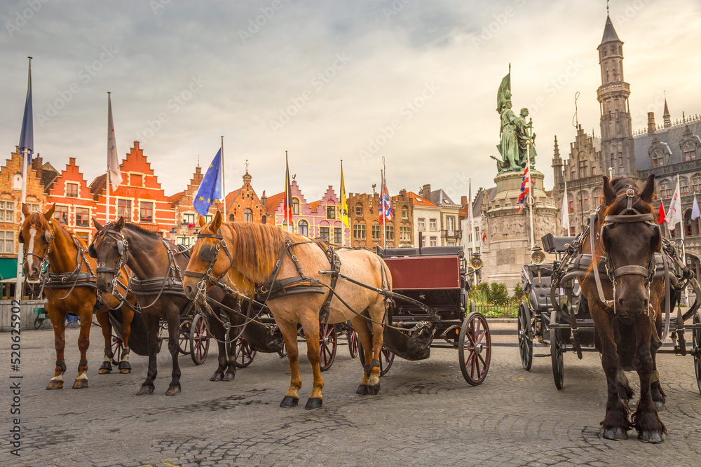 Fototapeta premium Bruges market square with flemish architecture and horse carriages, Belgium