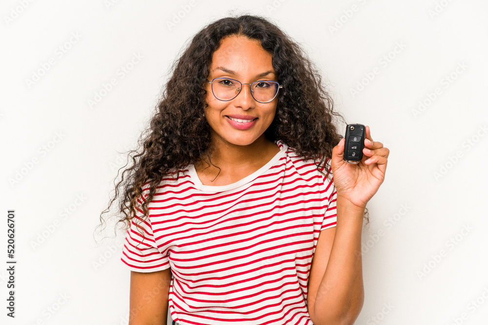 Young hispanic woman holding car keys isolated on white background happy, smiling and cheerful. Young hispanic woman holding car keys isolated on white background happy, smiling and cheerful.