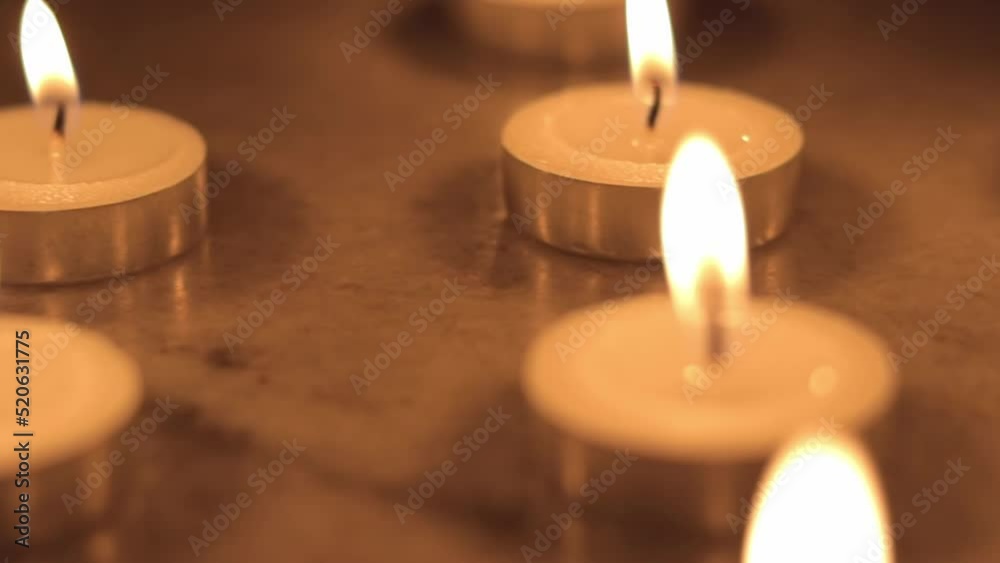 Tealight candles in the dark. Camera moving around the candles. Tealight candles in the dark. Camera moving around the candles.
