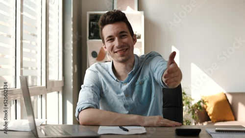 Smiling businessman extending hand for handshake at camera, friendly hr manager greeting candidate on interview, offering deal
