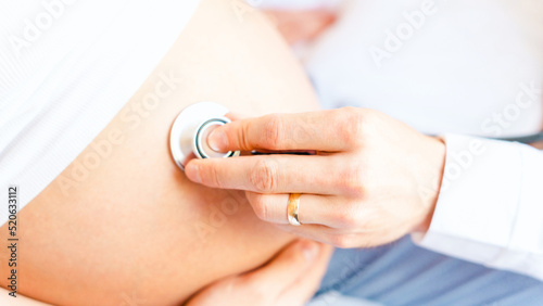 Pregnant patient doctor hospital. Medical clinic for pregnancy consultant. Doctor examining pregnancy woman belly holding stethoscope. Pregnancy, medicine health care concept.