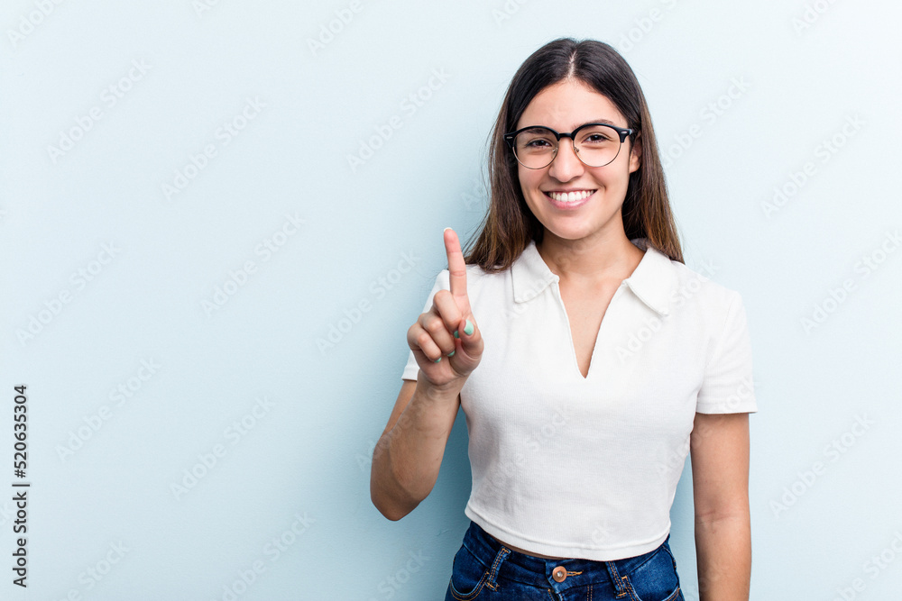 Young caucasian woman isolated on blue background showing number one with finger. Young caucasian woman isolated on blue background showing number one with finger.