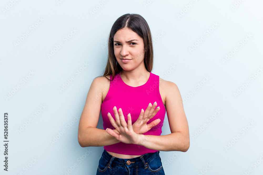 Young caucasian woman isolated on blue background doing a denial gesture Young caucasian woman isolated on blue background doing a denial gesture