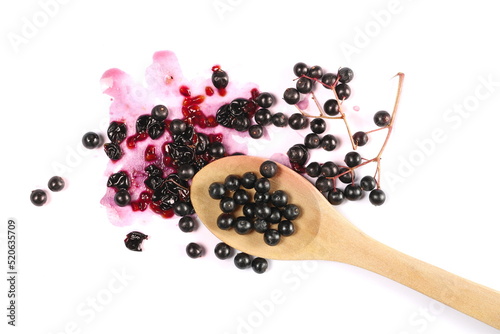 Elderberries, elder berries pile in wooden spoon, isolated on white, top view