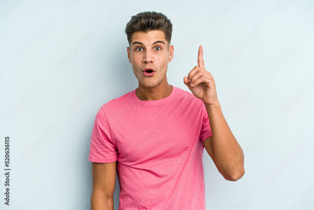 Young caucasian man isolated on blue background having an idea, inspiration concept.