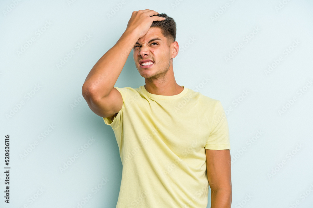 Young caucasian man isolated on blue background forgetting something, slapping forehead with palm and closing eyes. Young caucasian man isolated on blue background forgetting something, slapping forehead with palm and closing eyes.