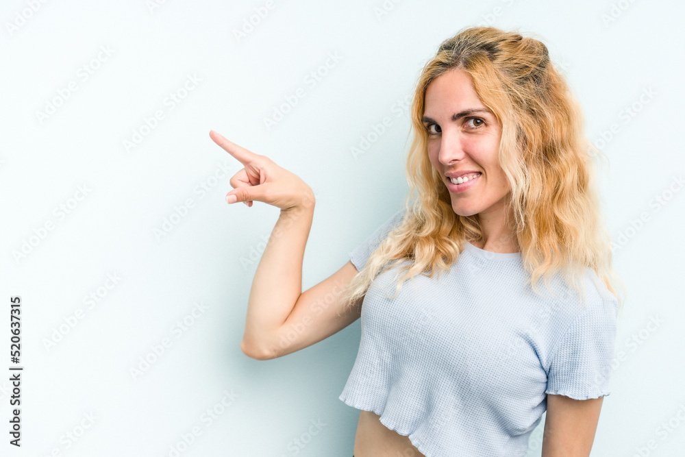 Young caucasian woman isolated on blue background smiling cheerfully pointing with forefinger away. Young caucasian woman isolated on blue background smiling cheerfully pointing with forefinger away.
