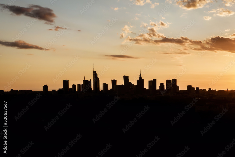 Black silhouette of skyscrapers of a big city in the distance on the horizon.