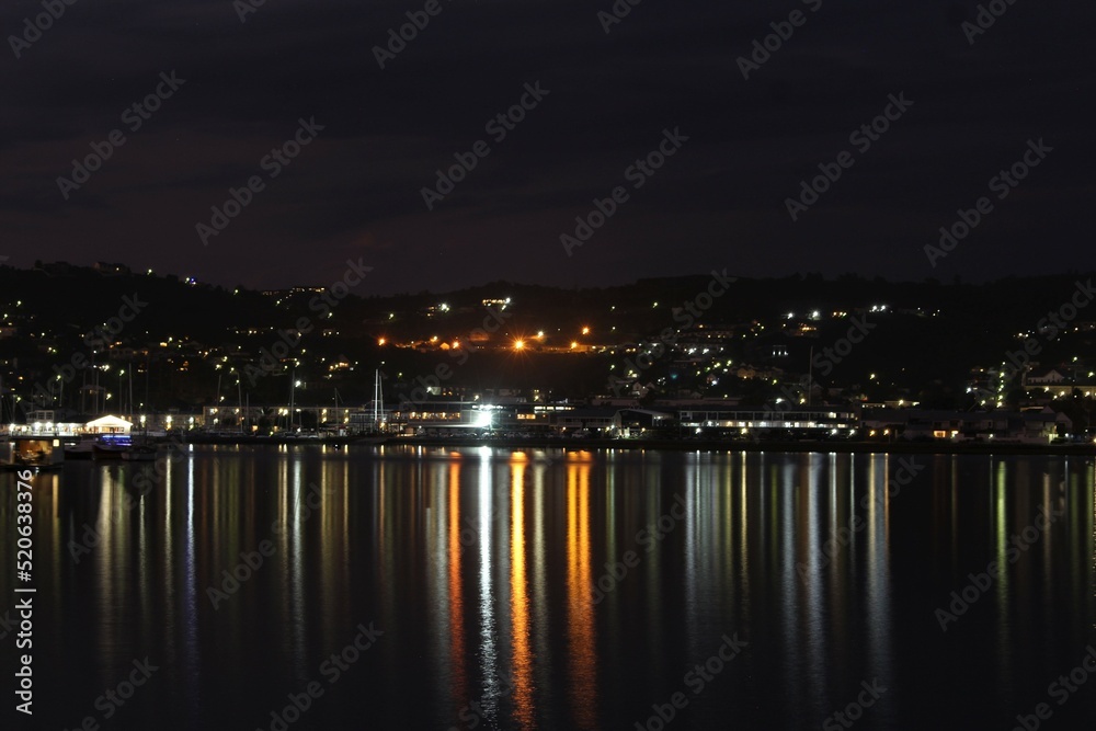 Knysna at night - reflections of city lights on calm sea water