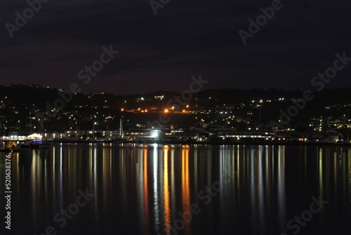 Knysna at night - reflections of city lights on calm sea water © Vladimra